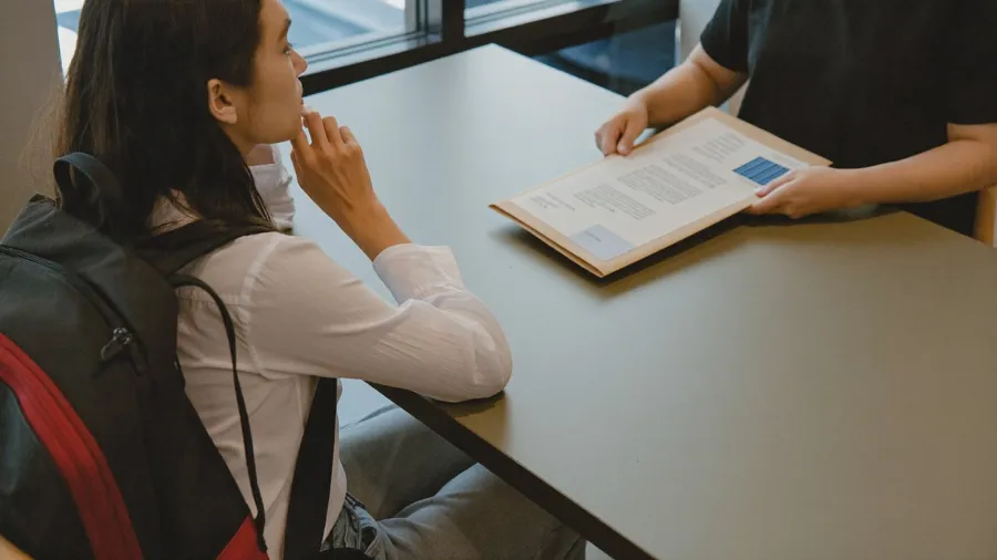 Jeune femme avec un sac à dos reçue par une conseillère de Mission Locale pour une inscription sans domicile fixe