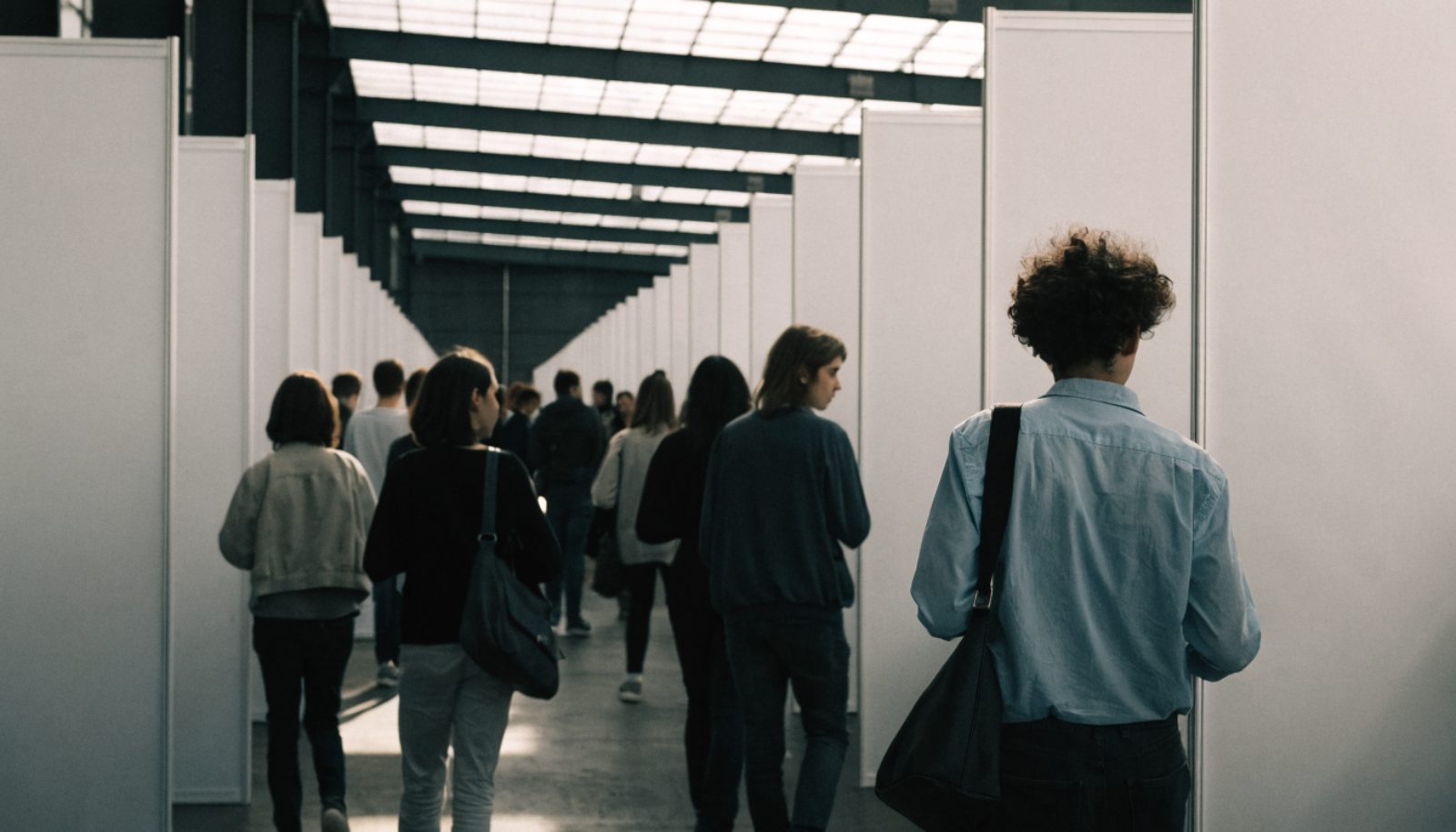 Jeunes visiteurs entre les stands d'un salon de l'emploi et de l'alternance