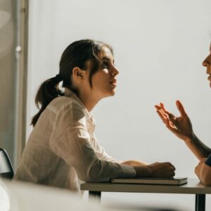 Jeune femme en entretien avec une recruteuse sur un stand de salon