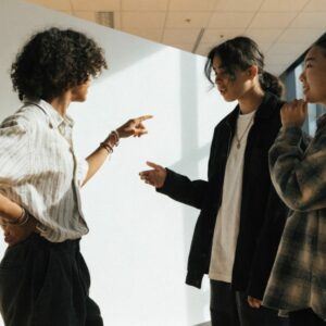 Trois jeunes devant un panneau d'information dans un hall de salon